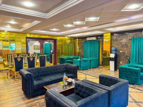 a lobby with blue couches and a table at Royal Mansion Hotel in Multan