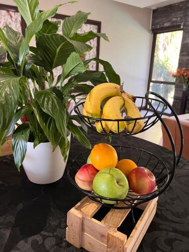 two baskets of fruit on a table with a plant at One O Eight Boutique Hotel in Benoni