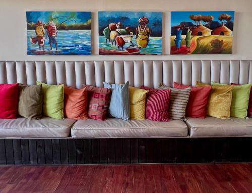 a couch filled with colorful pillows in a room at One O Eight Boutique Hotel in Benoni