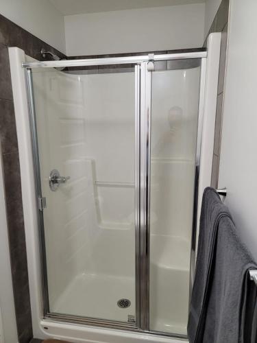 a shower with a glass door in a bathroom at Exquisite Entire 4- Bed rooms vacation home! in Calgary