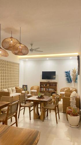 a living room with tables and chairs and a tv at Santai Suites Nusa Dua in Nusa Dua