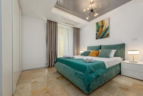 a bedroom with a large bed with a green headboard at Astria Siena - Complex Novum in Olimp