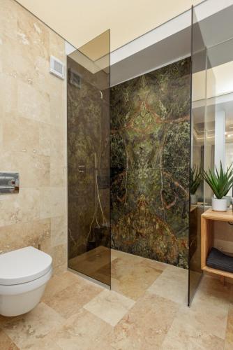 a bathroom with a toilet and a painting on the wall at Astria Siena - Complex Novum in Olimp