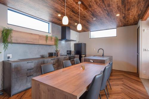 a kitchen with a large wooden table and chairs at Gold Valley Villa B in Futtsu