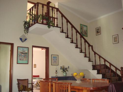a staircase in a living room with a wooden table at Campo de Oleandros in Lourinhã
