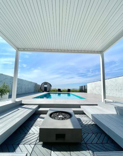 a swimming pool with a white pergola and a swimming poolvisor at Gold Valley Villa B in Futtsu
