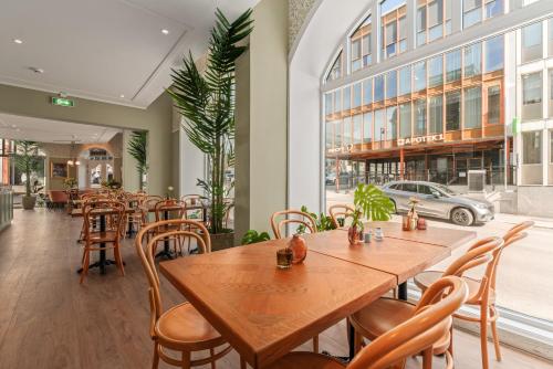 a restaurant with wooden tables and chairs and a building at Hotel Breiseth in Lillehammer