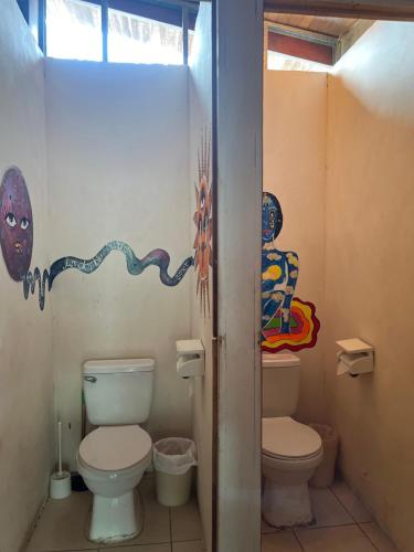 a bathroom with a toilet and a window at Woodstock Hostel in Sámara
