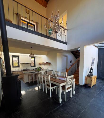 a kitchen and dining room with a table and chairs at Jaadooghar The Chitai Life in Almora