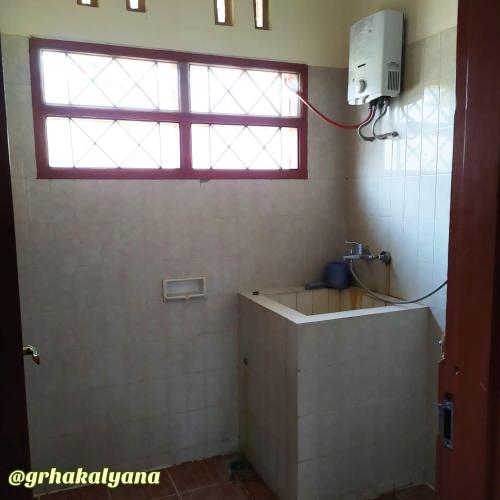 科贾扬Grha Kalyana Homestay的带水槽和窗户的浴室