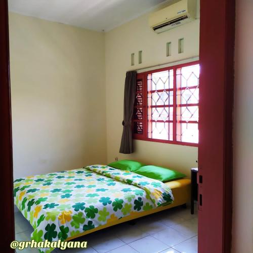 科贾扬Grha Kalyana Homestay的一间卧室，里面有一张床和一扇窗户。