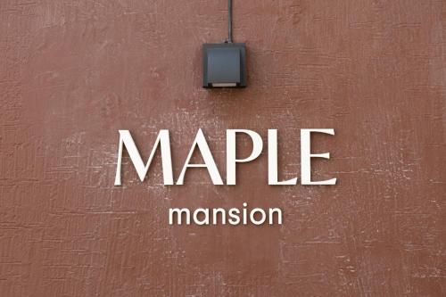a sign on a wall with the words maple mansion at MAPLE MANSION Hongdae in Seoul