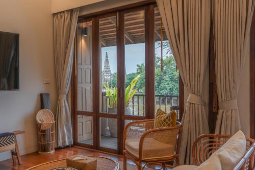 a living room with a large glass door with a balcony at Syama Residence and Café in Phra Nakhon Si Ayutthaya