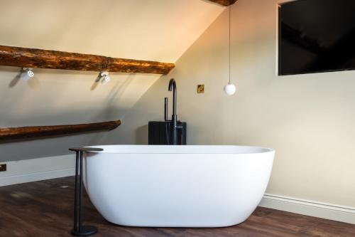 a large white bath tub in a room at Domain Boutique Rooms in Lancaster