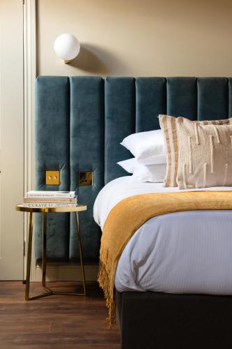 a bedroom with a blue headboard and a bed at Domain Boutique Rooms in Lancaster