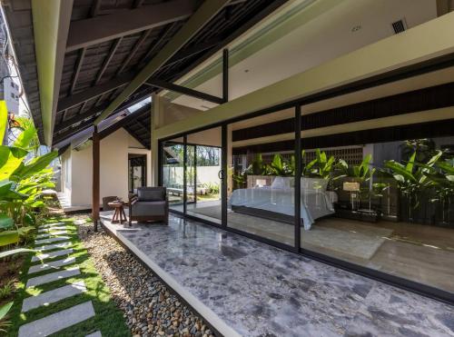 a bedroom in a house with large glass windows at Ha Garden house in Nha Trang