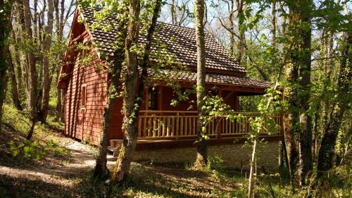 une cabane en rondins au milieu d'une forêt dans l'établissement Le nid de l'écureuil, à Lavercantière