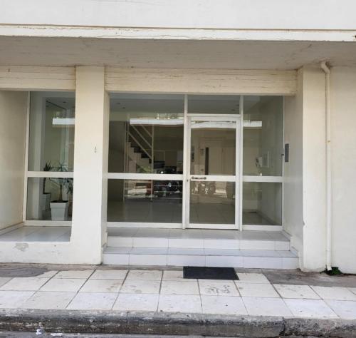 an empty building with glass windows and a pillar at Kalamata Apartment Beach Front in Kalamata