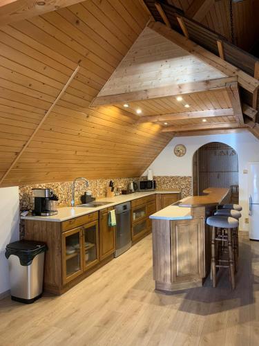 a large kitchen with wooden floors and a wooden ceiling at Chalupa pod Posklu in Hutisko
