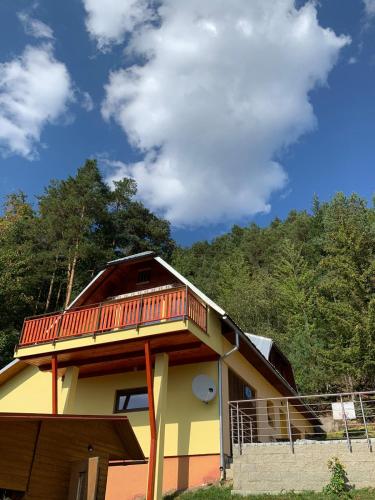 a house with a balcony on top of it at Chalupa pod Posklu in Hutisko