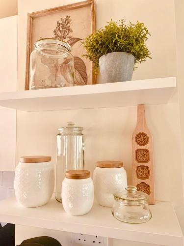 a shelf with glass jars and plants on it at Garden Villa in Ţāqah