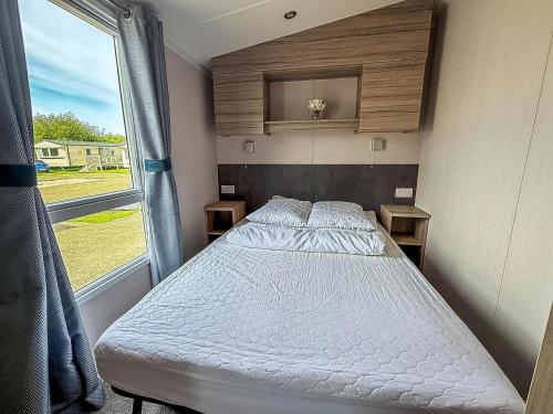 a bed in a small room with a window at 6 Berth Caravan With Decking At Sunnydale Holiday Park Ref 35243Kg in Louth