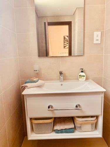 a bathroom with a white sink and a mirror at Garden Villa in Ţāqah
