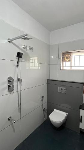 a white bathroom with a toilet and a shower at Vintage Coffee Premium Villa in Pinangode
