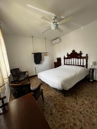 a bedroom with a bed and a ceiling fan at La casa de mamá in Lorca