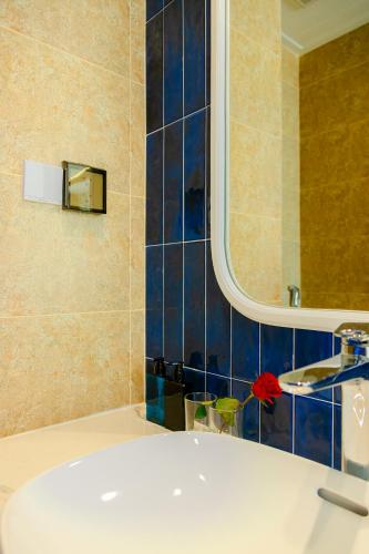 a bathroom with a white sink and a mirror at LCV Mũi Né Resort in Mui Ne