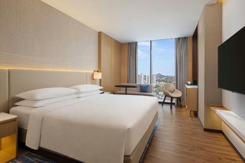 a large white bed in a hotel room with a window at Courtyard by Marriott Ranchi in Rānchī