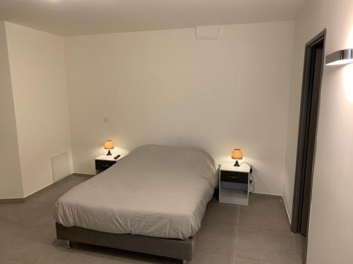 - une chambre avec un lit et deux lampes sur les tables dans l'établissement Grande chambre appartement Clara, à Chambéry