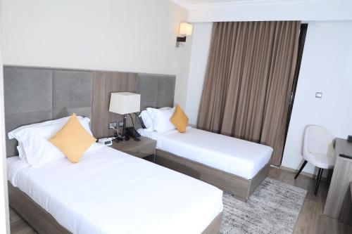 a hotel room with two beds and a desk at TH BonRoyal Hotel in Addis Ababa