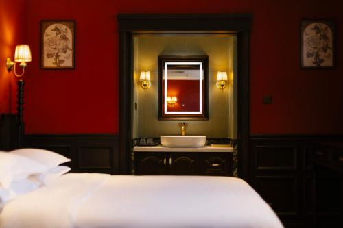 a bedroom with a bathroom with a sink and a mirror at Beijing Xiaofengxian Former Residence Hotel Tiananmen Square Qianmen Store in Beijing