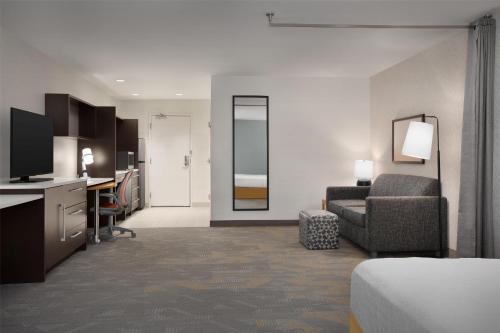 a hotel room with a couch and a chair and a desk at Home2 Suites by Hilton Sioux Falls Sanford Medical Center in Sioux Falls