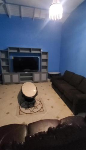 a living room with a couch and a flat screen tv at Michael's Beach Complex #2 in Ribishi