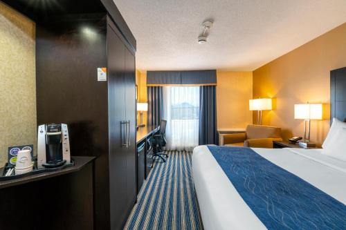 a hotel room with a bed and a desk at Comfort Inn in Saint Thomas