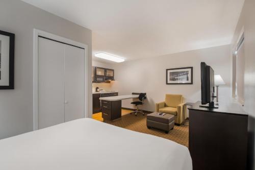 a hotel room with a bed and a desk and a chair at MainStay Suites Chattanooga Hamilton Place in Chattanooga