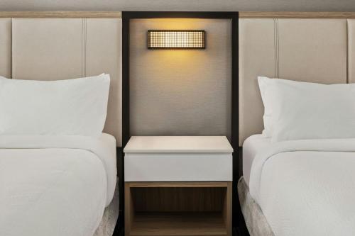 a room with two beds and a nightstand between them at SpringHill Suites by Marriott Bettendorf in Bettendorf