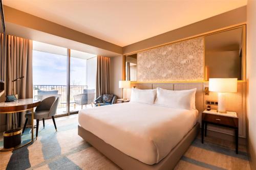 卡斯卡伊斯Legacy Hotel Cascais, Curio Collection By Hilton的一间配有床、书桌和桌子的酒店房间
