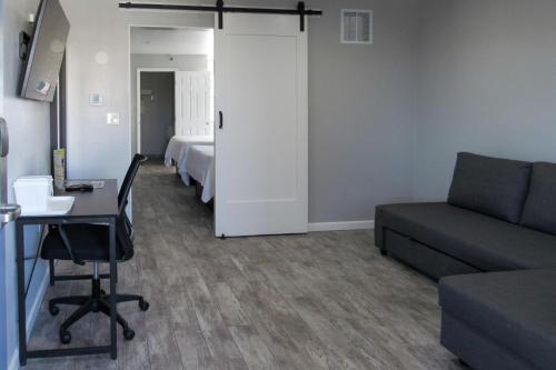a living room with a couch and a table and a bed at Capri Suites Anaheim in Anaheim