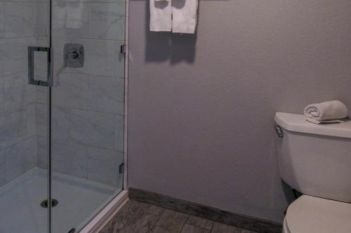 a bathroom with a shower and a toilet at Capri Suites Anaheim in Anaheim