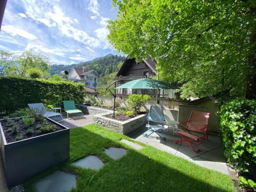 un patio con sillas y una sombrilla en Lebensfreude, en Dornbirn