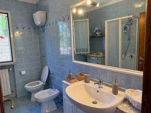 a bathroom with a sink and a toilet and a mirror at La Serenella in Porto Ercole