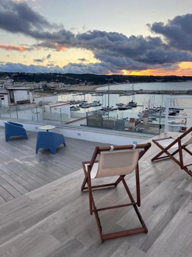 a chair on a roof with a marina with boats at North Wind Luxury Home in Vieste
