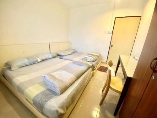 a bedroom with a large bed and a chair at OYO 90381 Chaah Homestay 3 in Segamat