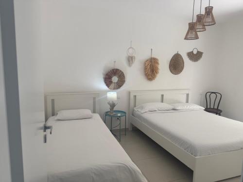 two beds in a room with white walls at Cocciu d’amuri in Terrasini
