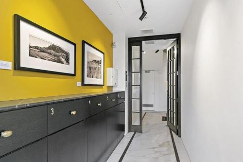a bathroom with a yellow wall and black cabinets at Historical 2 beds apartment with Harbour Views in OBay in Wellington