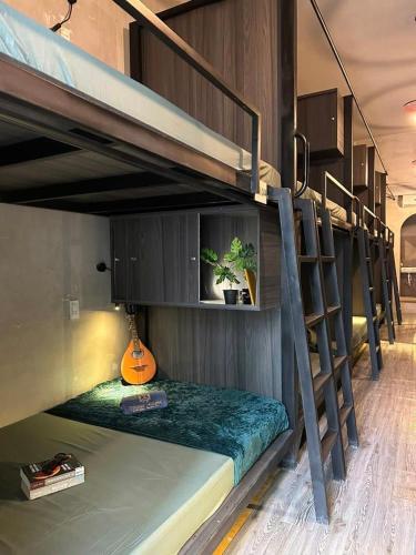 a room with two bunk beds with a guitar at Tzone's Hostel - Quiet Place in Ho Chi Minh City