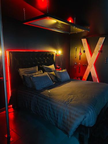 a bedroom with a bed in a room with red lights at Love room Spa nuits secrètes in Écuires